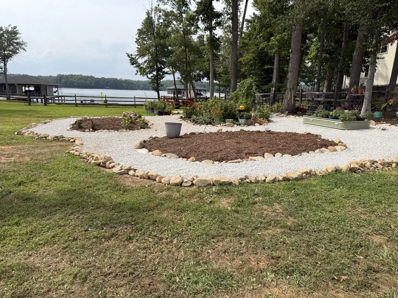 Curved mulched planting beds edged with rounded stones and white gravel